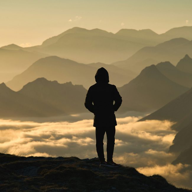 Homme debout face au lever du soleil, retrouvant un élan de vie et une énergie nouvelle.